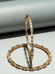 Elegant gold and diamond-studded hoop earrings with marquise and baguette-cut stones, artistically displayed against a modern backdrop.