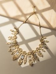 Delicate gold necklace with sparkling diamond pendants displayed on a deep navy satin background.