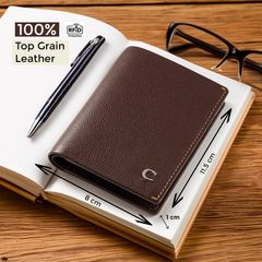 Brown top-grain leather wallet with RFID protection (8 cm x 1 cm x 11.5 cm), displayed on an open notebook with a pen and glasses.