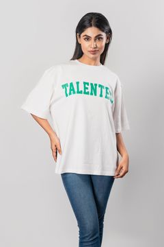 Close-up of a woman in a white T-shirt reading 'Talented' in green, styled with denim jeans